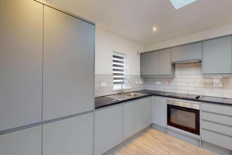 Modern L-shaped kitchen with sleek grey cabinet...