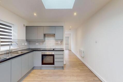 Bright modern galley kitchen with grey handlele...