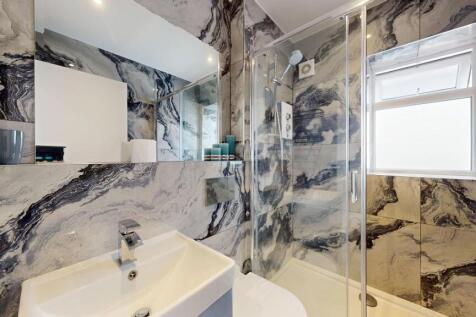 Bright, modern bathroom with striking marble-ef...