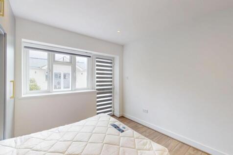 Bright, freshly painted bedroom with a large wi...