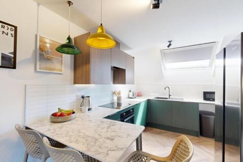 Bright, modern kitchen with marble-effect break...