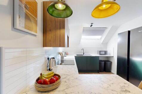 Bright modern kitchen with marble-effect workto...