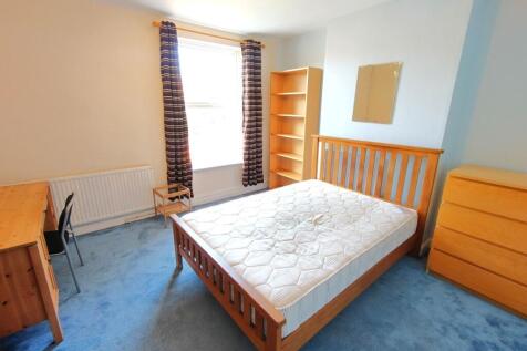 Bright double bedroom with a wooden double bed,...