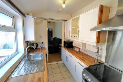 Bright galley kitchen with a large window, wood...