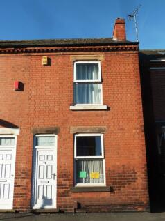 Sunlit red-brick terraced house facade with a w...