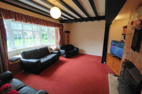 Bright living room with a large bay window look...