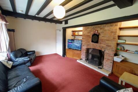 Spacious living room with exposed ceiling beams...