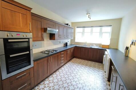 Bright, long galley kitchen with dark worktops,...