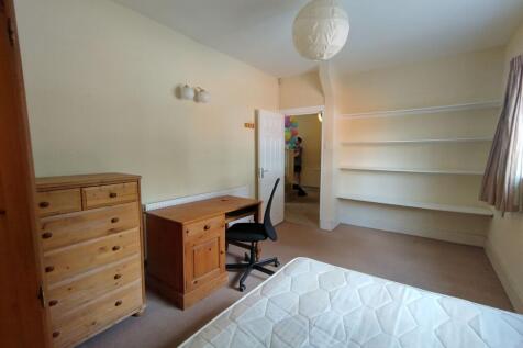 Bright double bedroom with a large window, buil...