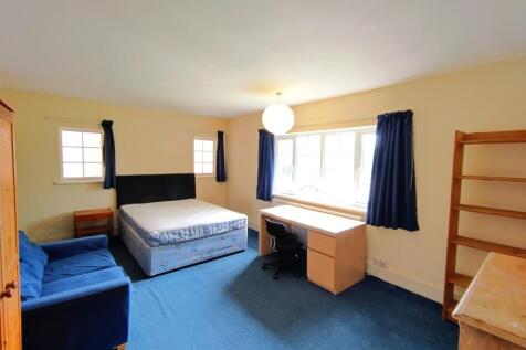 Bright, spacious bedroom with a large window le...