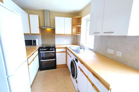 Bright modern kitchen with light wood counterto...