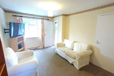 Bright, comfortable living room with pale walls...