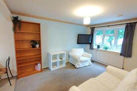 Bright, simply furnished living room with large...