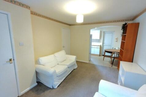 Bright, tidy living room with white slipcovered...