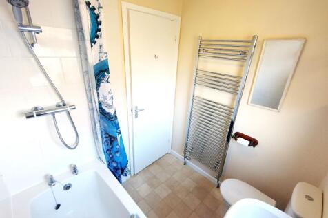 Bright, well-maintained bathroom with a bathtub...