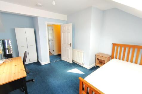 Bright, freshly painted bedroom with a wooden d...