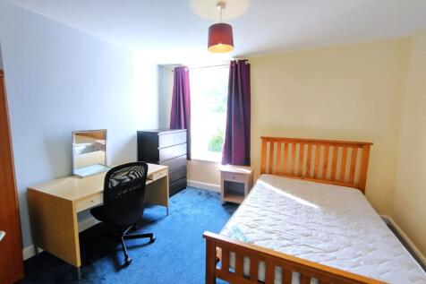 Bright, well-presented bedroom with a wooden do...