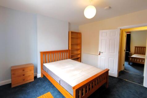 Bright, neat double bedroom with a wooden bed f...
