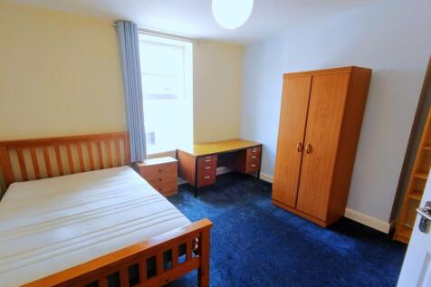 Bright, simply furnished bedroom with a wooden ...