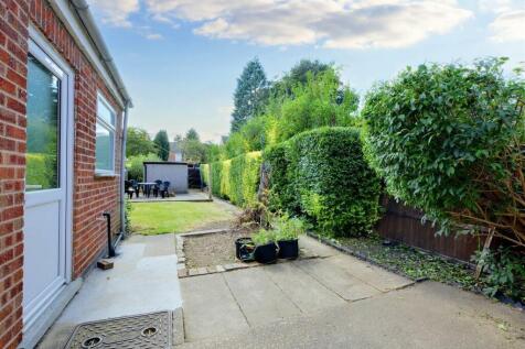 Well-maintained rear garden with a paved patio,...