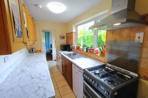 Bright galley kitchen with marble-effect workto...