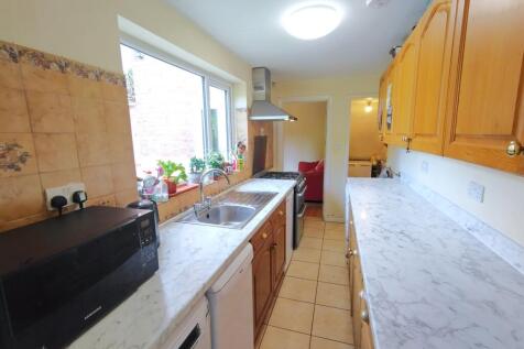 Bright galley kitchen with white marble-effect ...