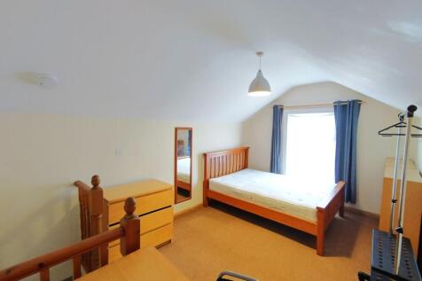 Bright, neatly presented bedroom with a wooden ...