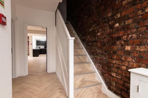 Bright, modern hallway with herringbone wood fl...