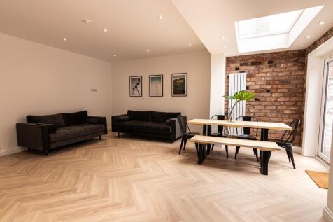 Bright, modern living and dining area with herr...