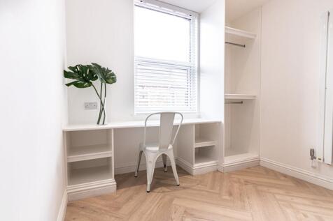 Bright, minimalist bedroom nook with built-in d...