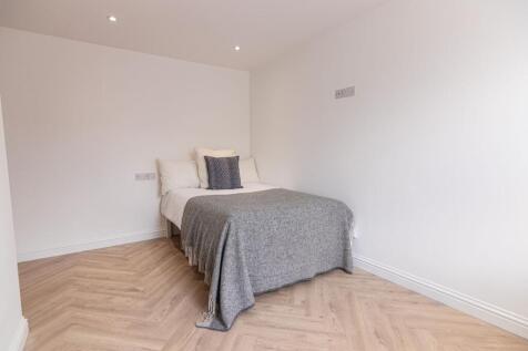 Bright, simple double bedroom with neutral deco...