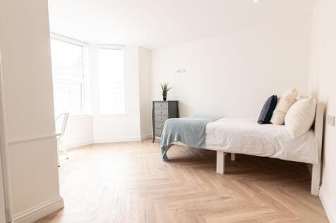 Bright, freshly decorated bedroom with large ba...