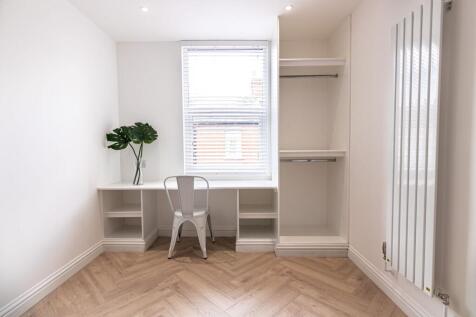 Bright, freshly decorated bedroom with built-in...