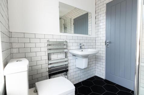 Bright modern bathroom with white subway tiles,...