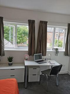 Bright, tidy bedroom with a study area by wide ...