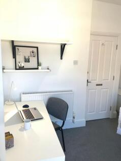Bright, tidy study nook with a long white desk,...