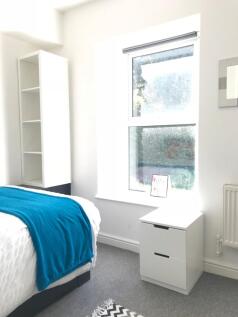 Bright, modern bedroom with large sash window l...