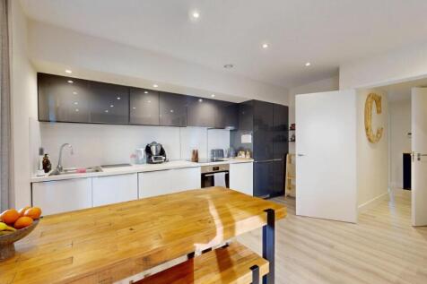 Modern, well-lit kitchen with ample counter spa...