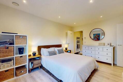 A bright and welcoming bedroom featuring a comf...