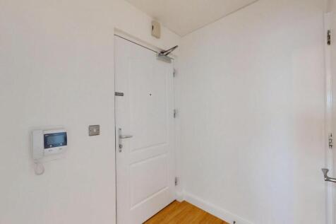 Bright and clean hallway with white walls and w...
