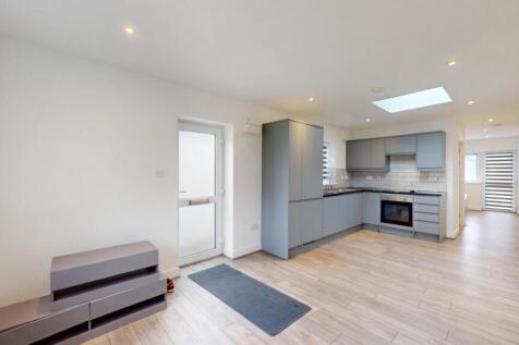 Bright open-plan kitchen with modern fitted uni...