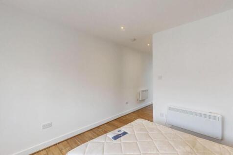 Bright, simply furnished bedroom with clean whi...