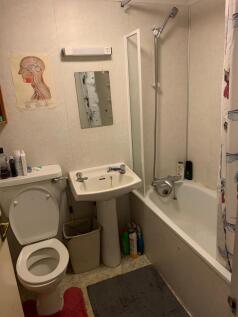 Compact three-piece bathroom with a bathtub and...