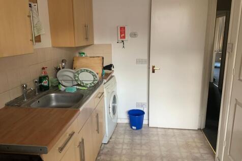 Practical galley-style kitchen with light wood ...