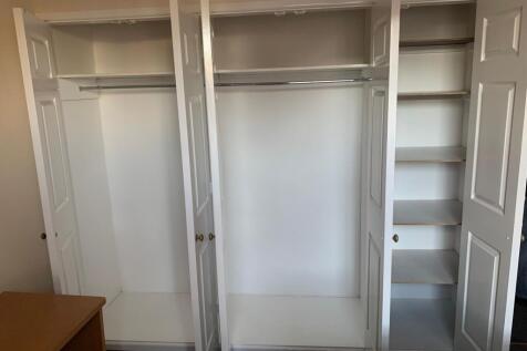 Bright built-in wardrobe with multiple hanging ...