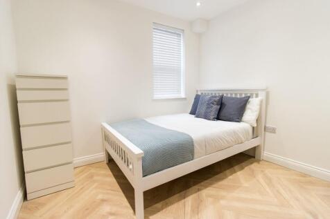 Bright, freshly decorated bedroom with pale woo...