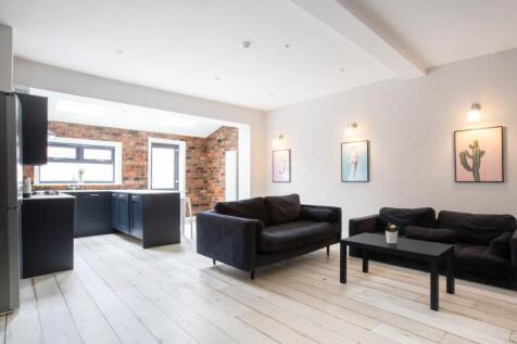 Bright, stylish open-plan living area with expo...