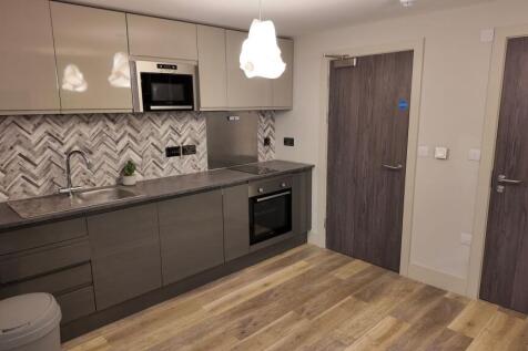Modern fitted kitchen with grey cabinets, integ...
