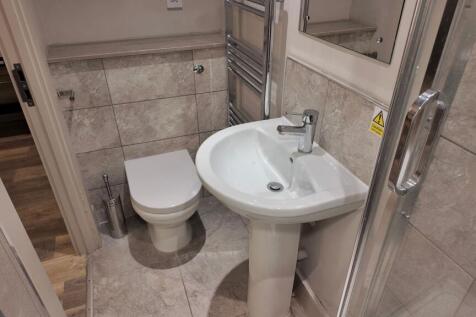 Well¿finished bathroom with tiled walls and flo...