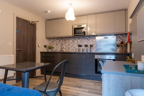 Modern kitchen area with sleek grey cabinetry, ...